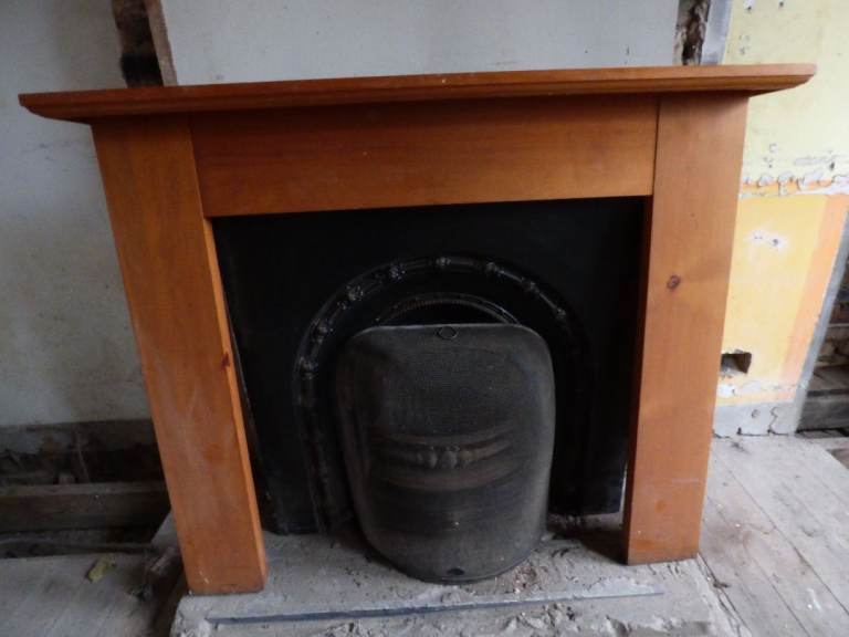 Cast iron fireplace and pine mantel