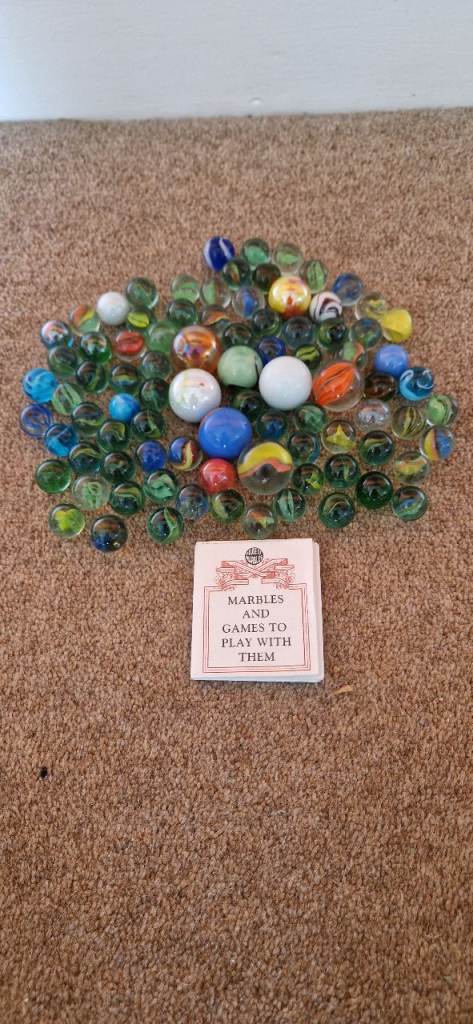 86 GLASS MARBLES IN STORAGE JAR. EXCELLENT CONDITION.