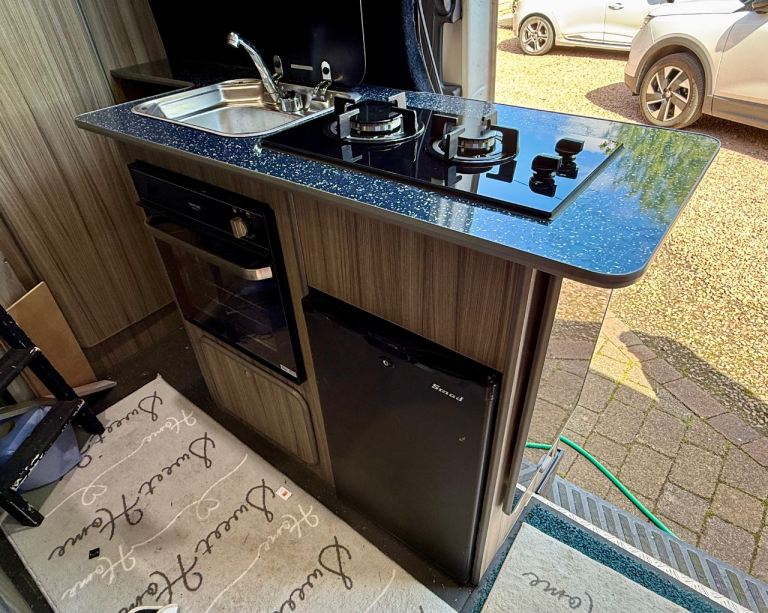 Camper van kitchen pod, fridge, gas oven/grill, gas hob and sink with extendable table