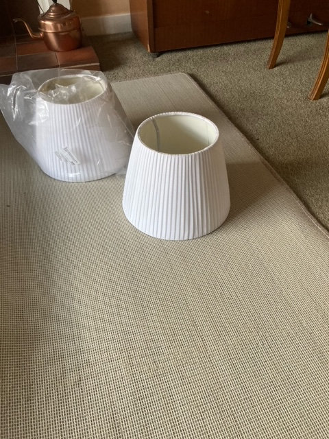 Two white, pleated lampshades