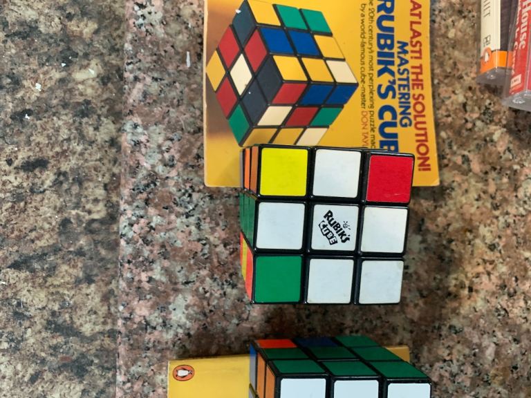 Two vintage Rubix cubes with cheat books