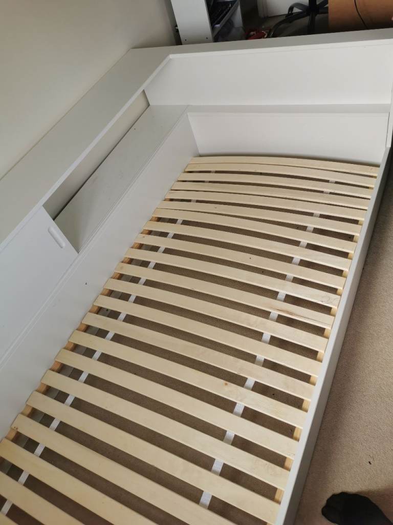 White single bed with built in sliding door storage. 