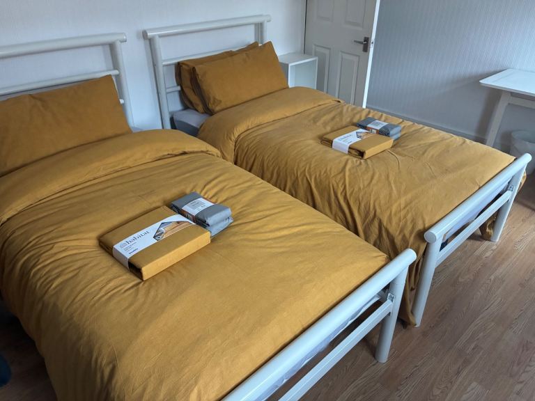 Two Single Argos Home Avalon White Metal Bed Frames with Matresses, Pillows, Quilts and Covers.