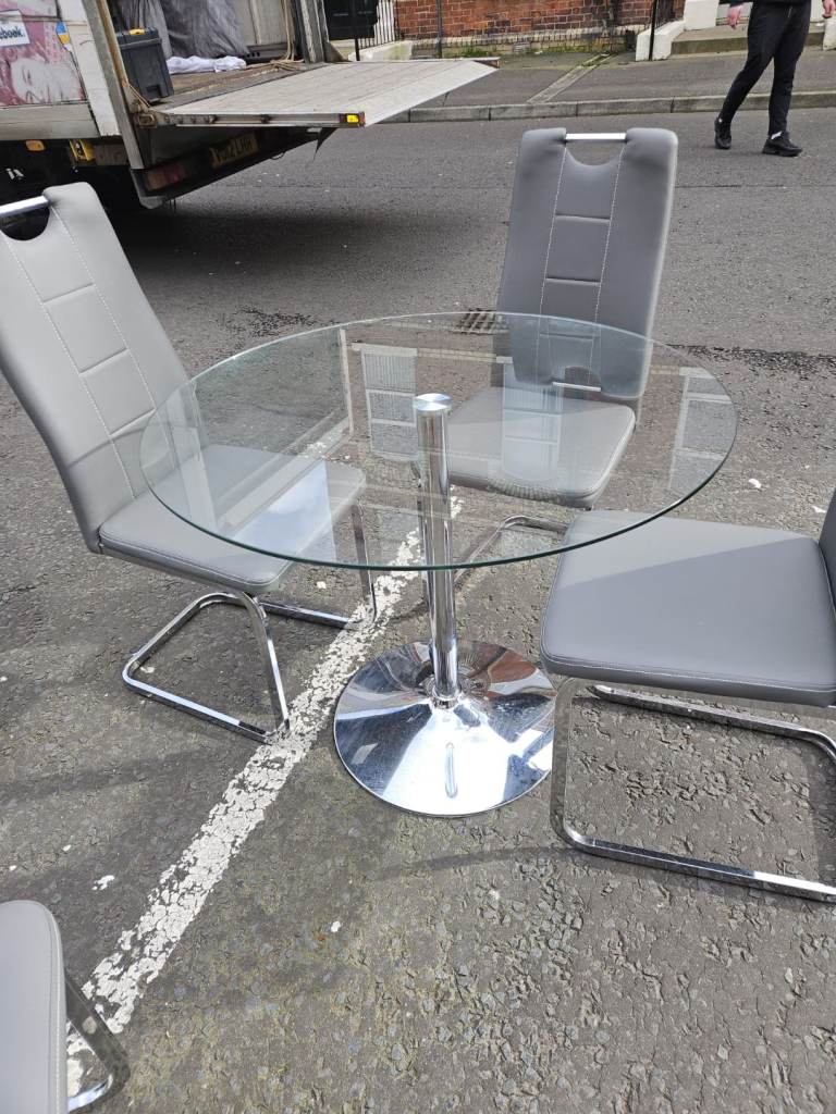 Round glass table and 4 grey leather chairs 