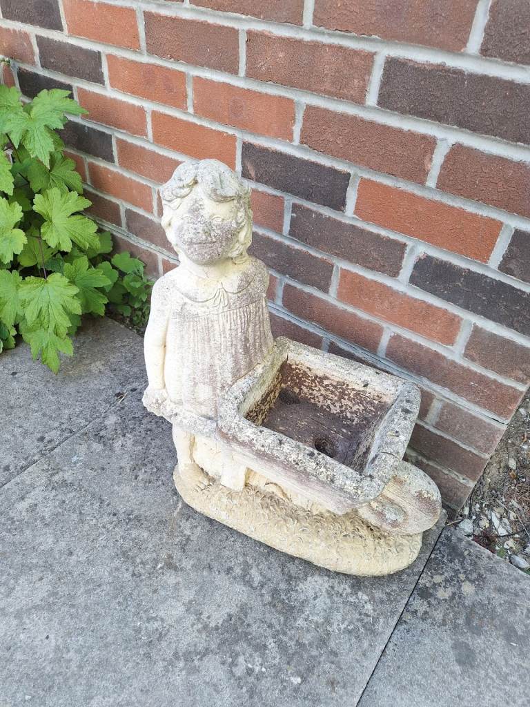 Weathered garden planter girl with a wheelbarrow 