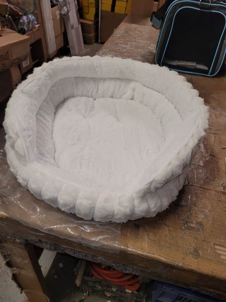 A new soft touch white soft fluffy cat bed .