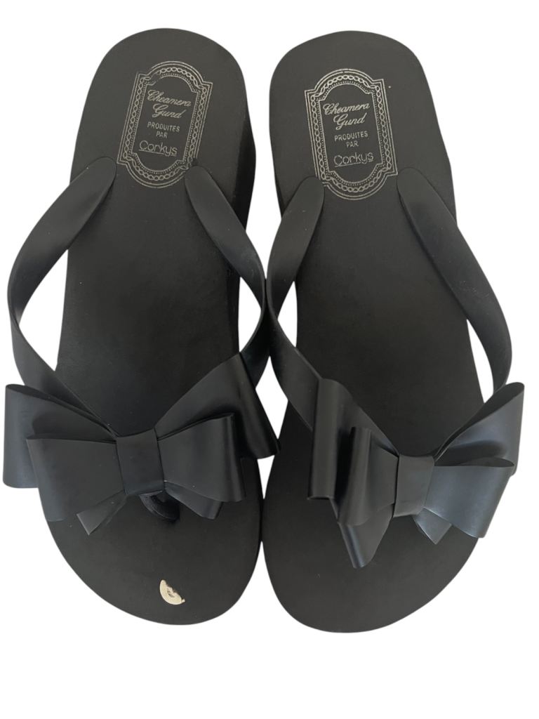 These are Charlie Paige women's black jelly flip flop sandals featuring a large bow. 
