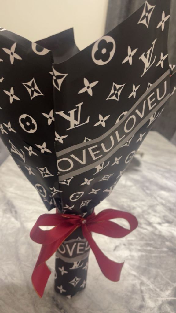 Red roses with diamonds on it wrapped in paper